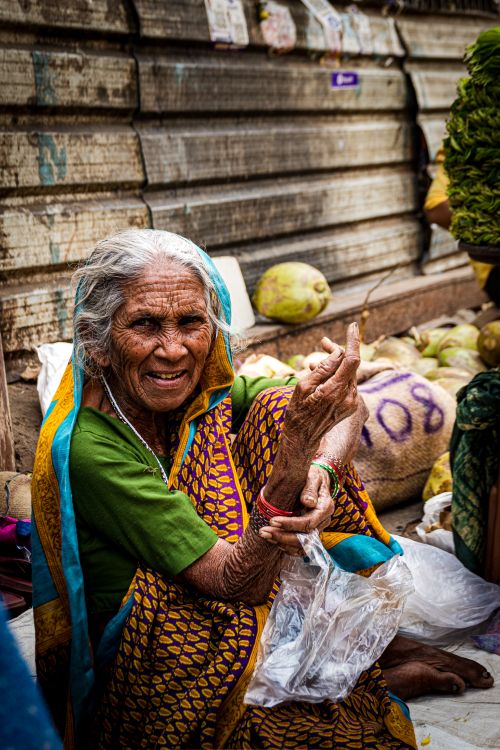 Free Portrait of an elderly woman in a vibrant sari smiling at a market in Mumbai, showcasing Indian culture. Stock Photo