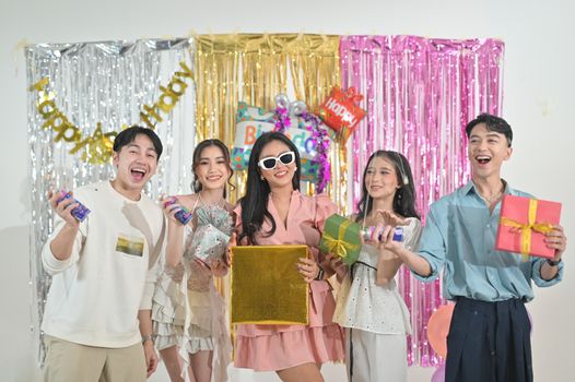 A vibrant birthday celebration with young adults in Indonesia, exchanging gifts and enjoying the party atmosphere.