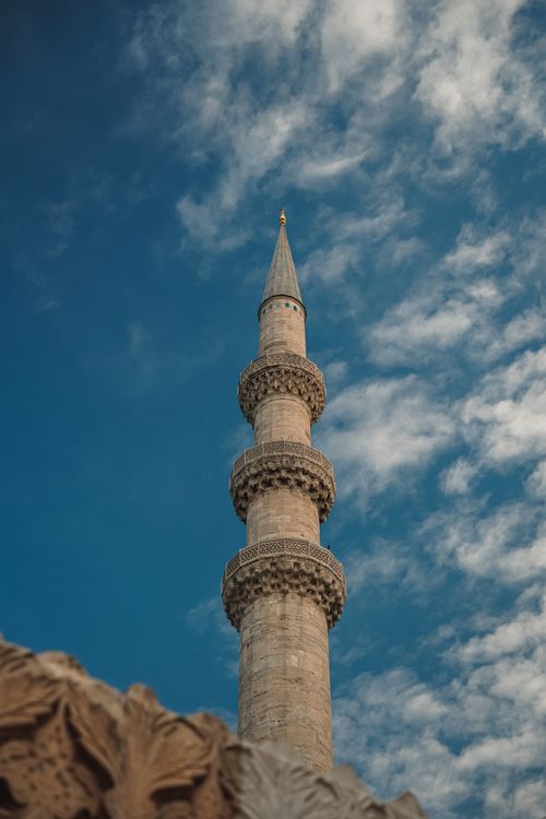 Free A stunning minaret in Istanbul, Turkey, under a vivid blue sky with clouds. Stock Photo