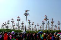 Panjat Pinang celebration with crowds in Jakarta, Indonesia, featuring prizes atop tall poles.