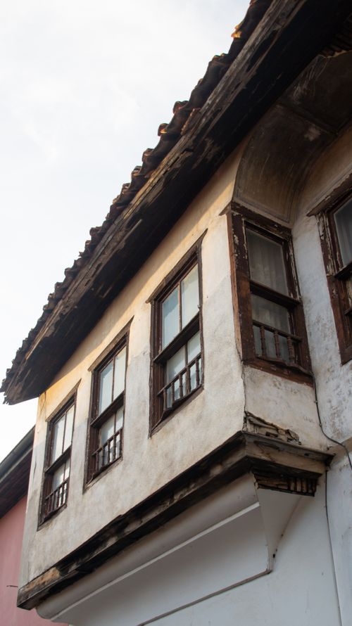 Free Close-up of a vintage house facade with aged wooden windows and rustic architecture. Stock Photo