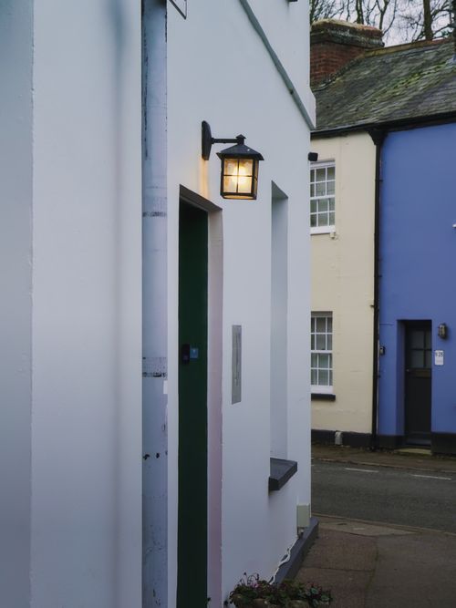 Free A quaint English street with lit lanterns, colorful facades, and classic architecture. Stock Photo