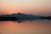 Serene Lake at Sunset with Mountain Silhouettes
