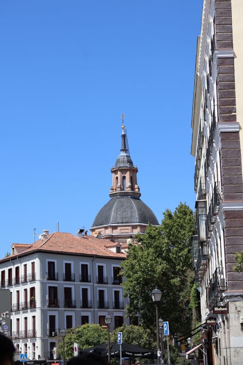 Free Captivating view of a historical dome amidst buildings in Madrid with clear blue sky. Stock Photo