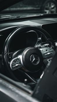 Close-up of Mercedes-Benz steering wheel showcasing luxury automotive interior design.