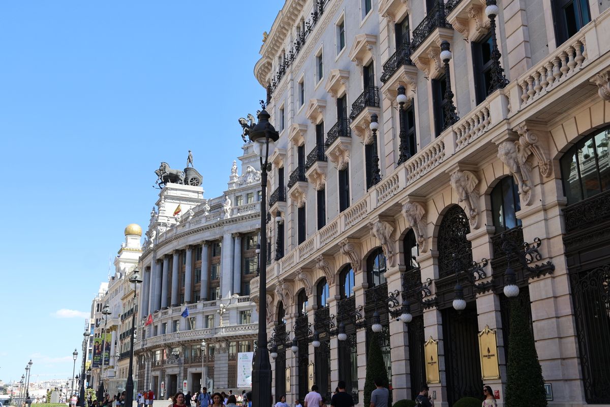 Beautiful architectural buildings in Madrid under a bright blue sky.