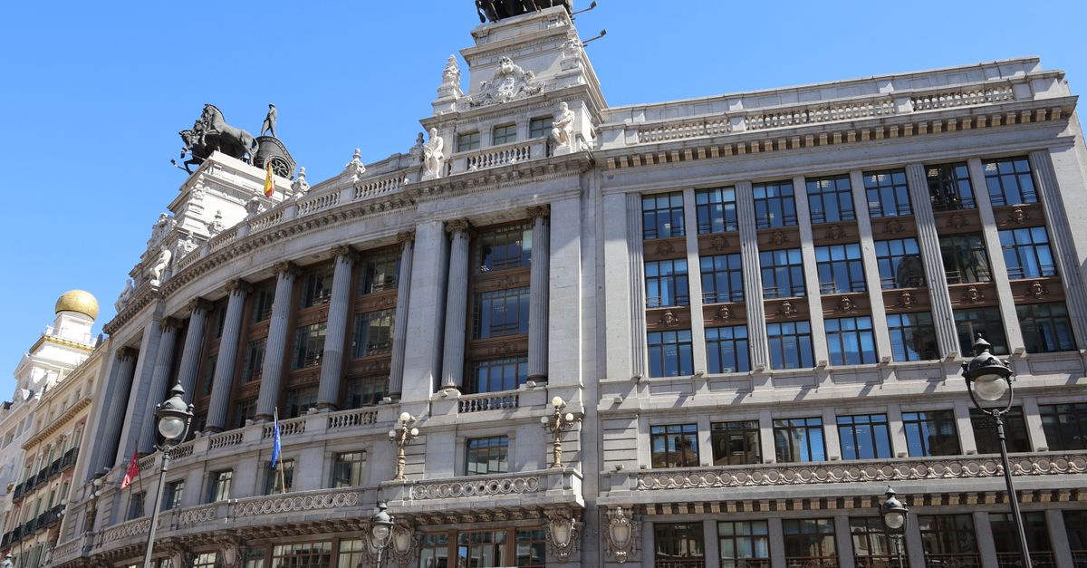 Impresionante fotografía de un edificio icónico con estatuas en Madrid bajo un cielo despejado.