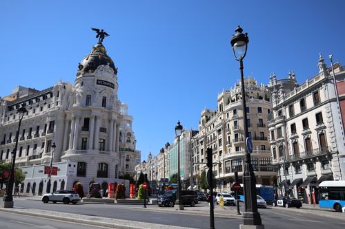 Free Iconic Metropolis Building on Gran Vía in Madrid under a clear blue sky. Stock Photo