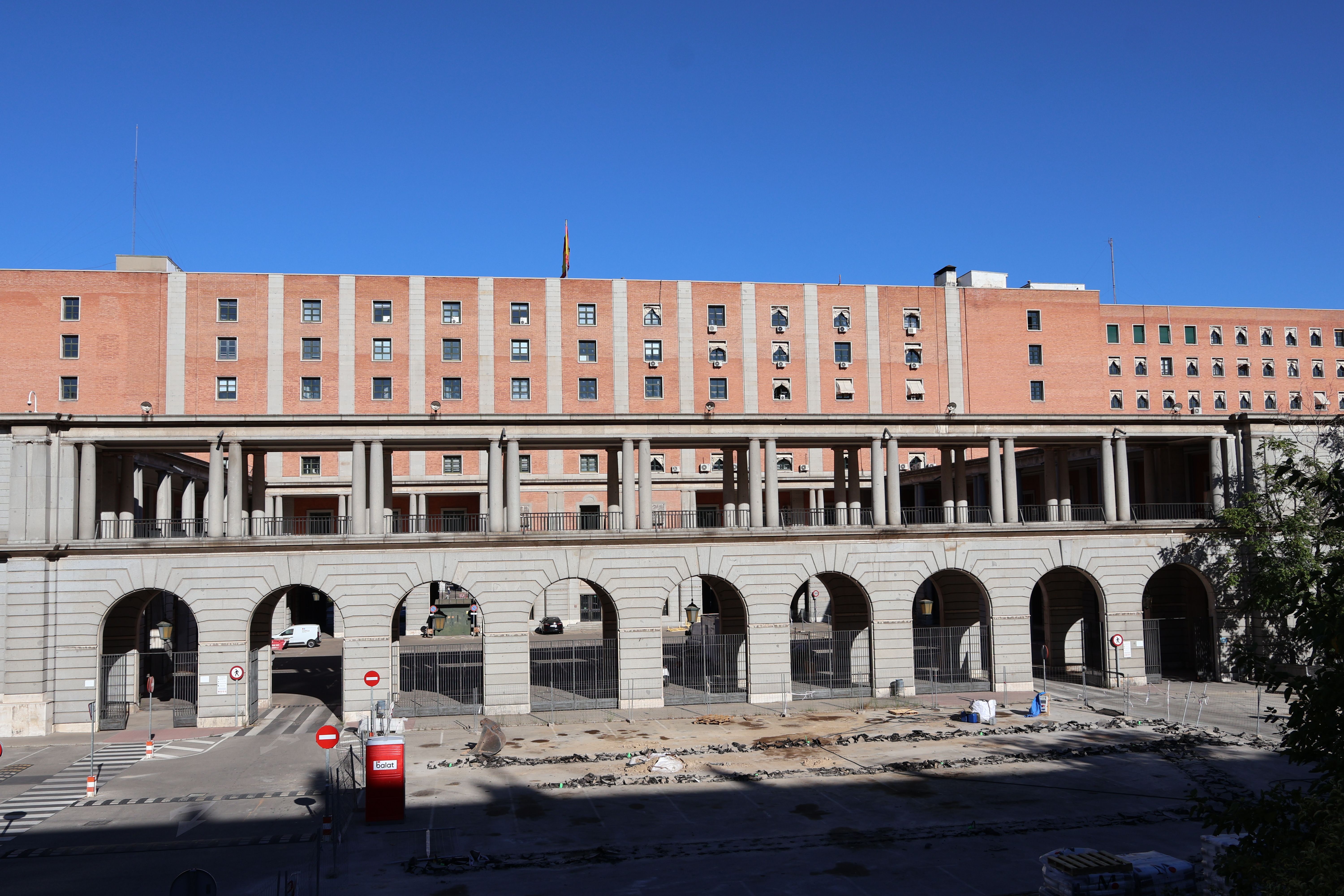 View of a historic building with arches and a walkway on a sunny day in Madrid.
