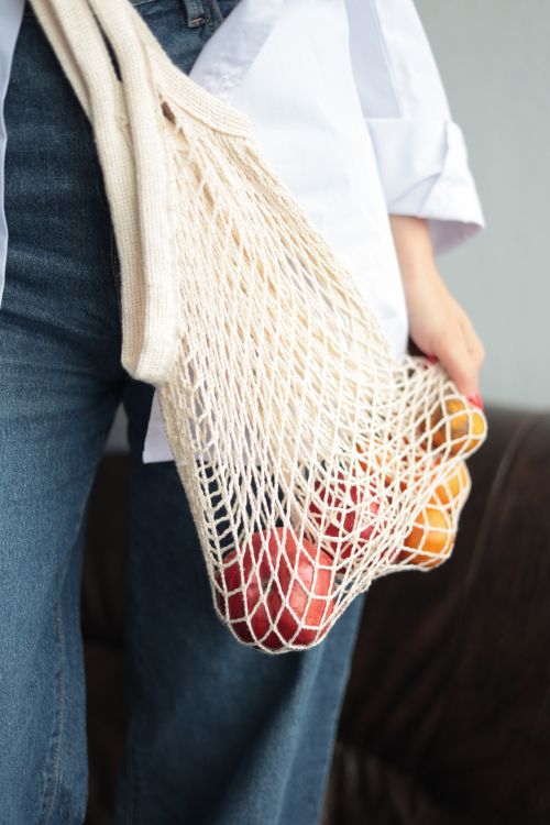 Free Sustainable shopping with a mesh bag filled with colorful fruits. Eco-friendly lifestyle emphasis. Stock Photo