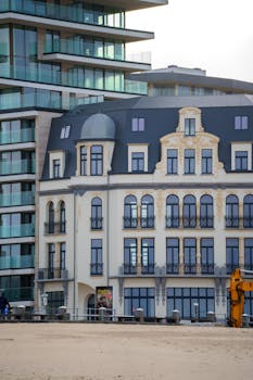 A juxtaposition of historic and modern architecture by the sandy beachside.