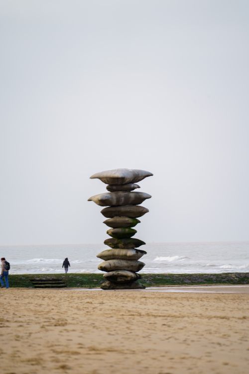 Free Artistic stone sculpture stacks on a serene beach setting, perfect for zen themes. Stock Photo