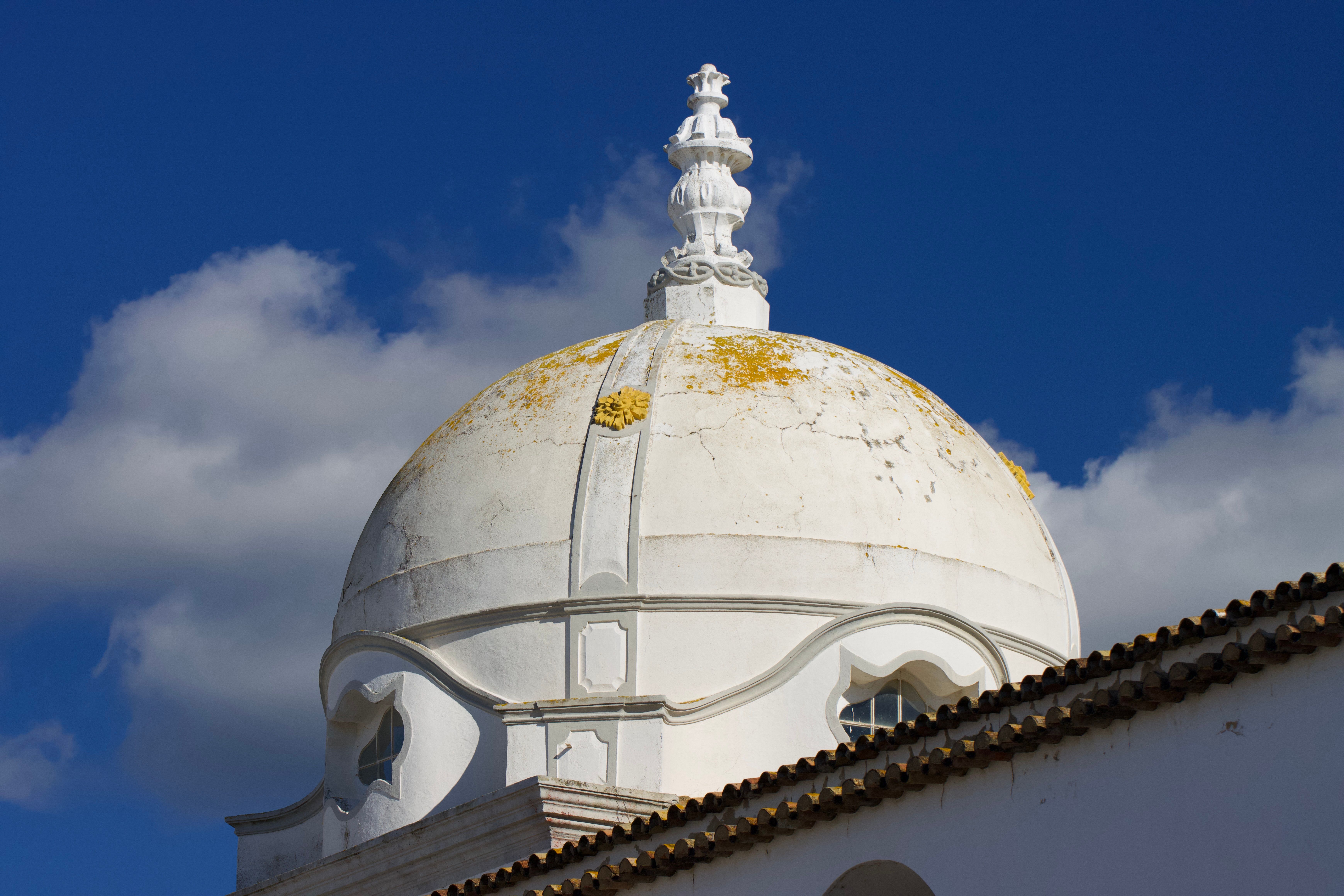 Stunning view of a classic dome against a blue sky in Olhão, Portugal.