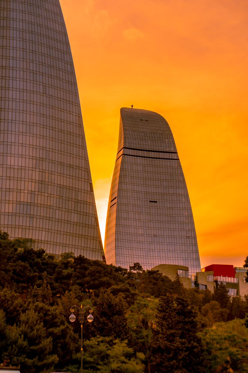 Flame Towers in Baku at sunset with vibrant orange sky