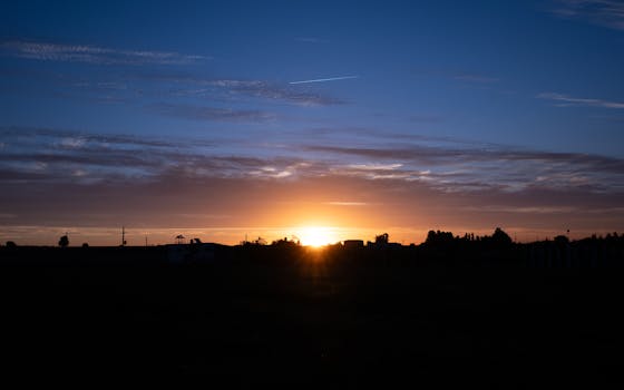 Capture the serene beauty of a sunset with vibrant orange and blue hues filling the sky.