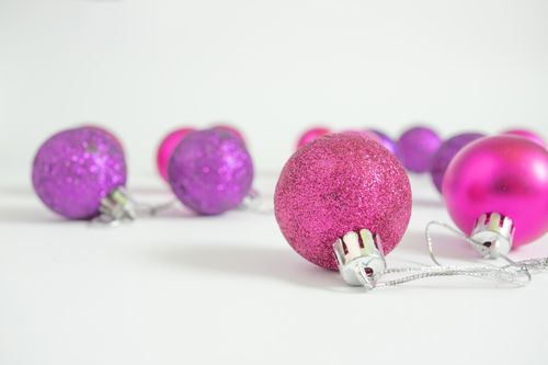 Free Close-up of shiny pink and purple Christmas ornaments on a white background. Stock Photo