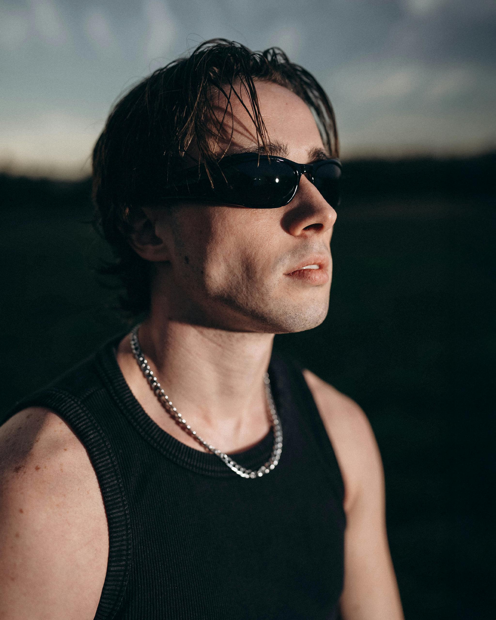 Gratis Hombre confiado con gafas de sol disfrutando de un entorno sereno al aire libre durante el anochecer. Foto de stock