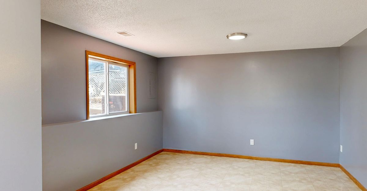 Bright and empty modern room with gray walls and natural light.