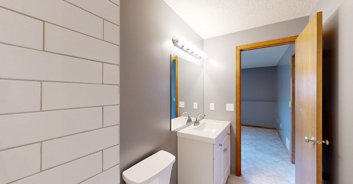 Contemporary bathroom with grey walls, sink, and mirror.