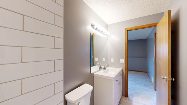 Contemporary bathroom with grey walls, sink, and mirror.