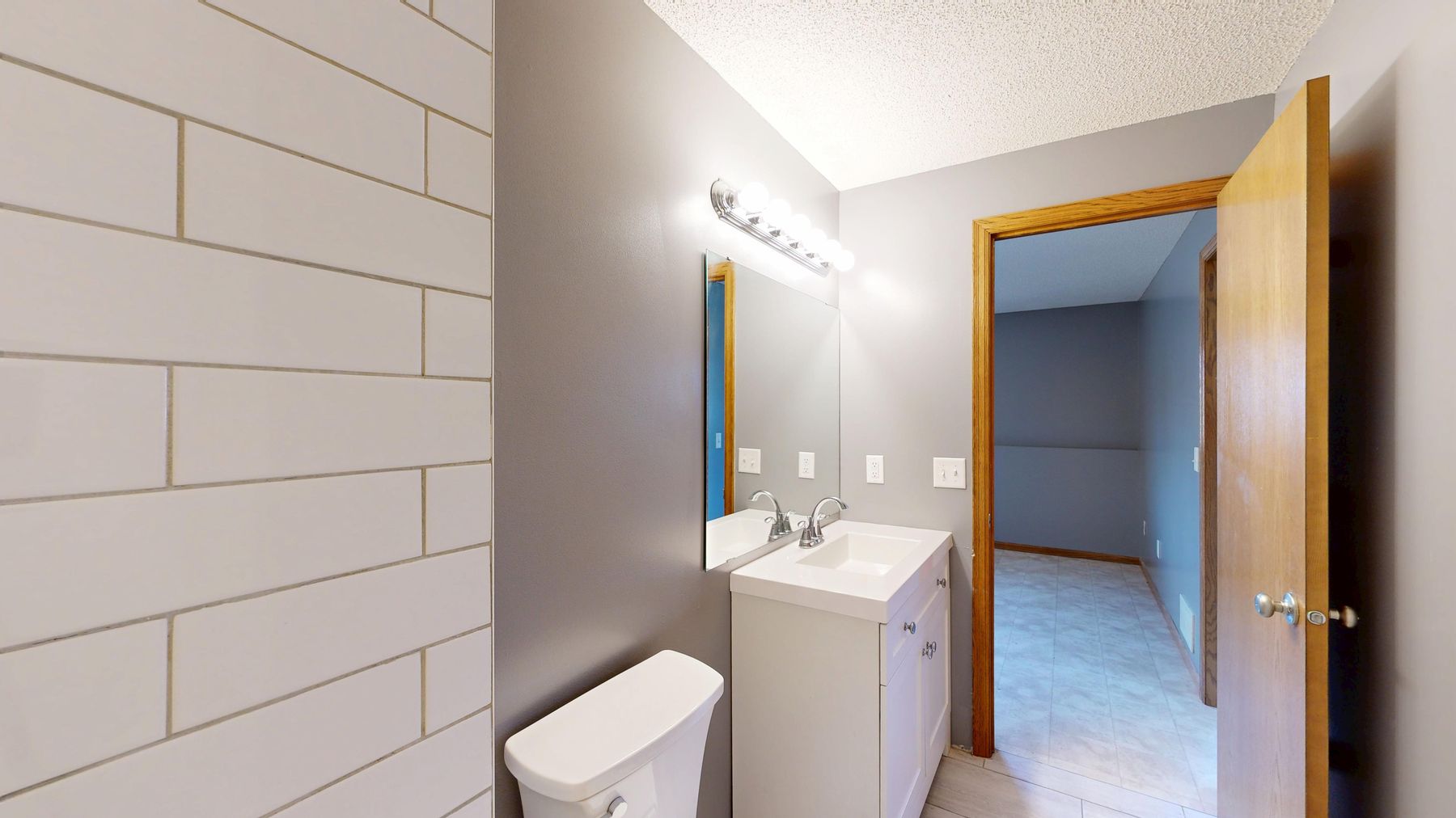 Compact grey bathroom with simple existing finishes and practical fixtures