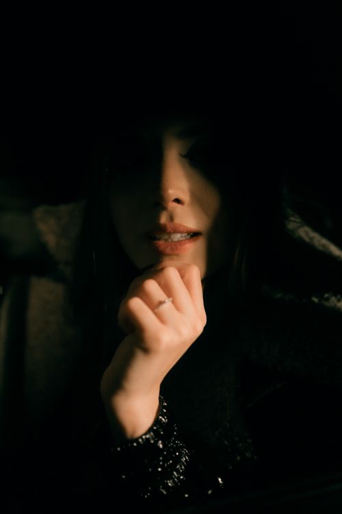 Free Stylish portrait of a woman in low light, showcasing mystery and elegance. Stock Photo