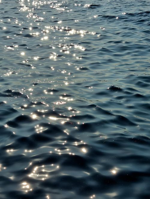 Free Glistening sunlight reflecting on peaceful ocean waves creating a serene view. Stock Photo