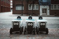 Three Autonomous Delivery Robots on City Street