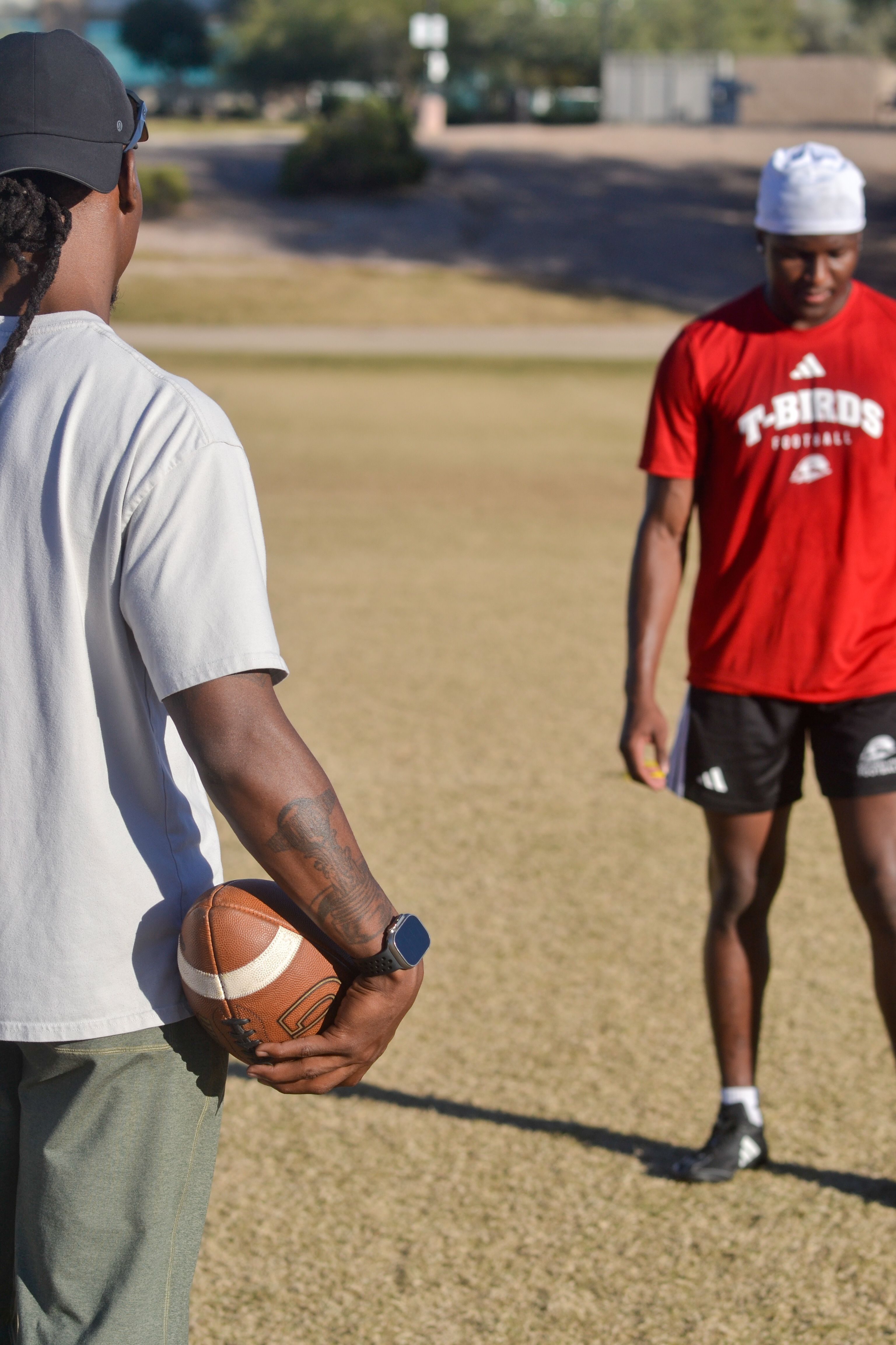Two young men practice football on a sunny day in Scottsdale, Arizona.