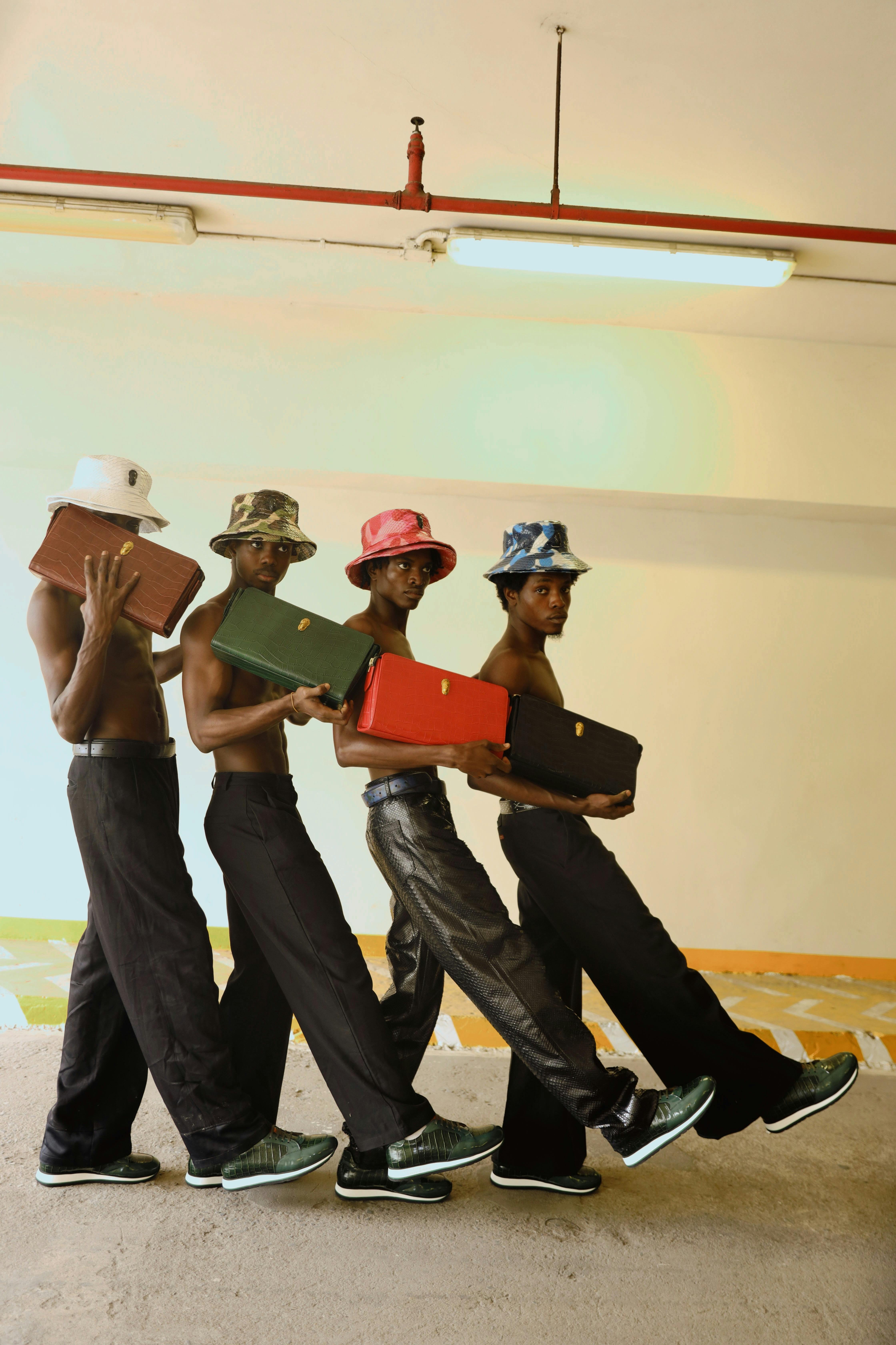 Gratis Gruppe menn som danser i stilige antrekk og holder fargerike vesker innendørs. Arkivbilde