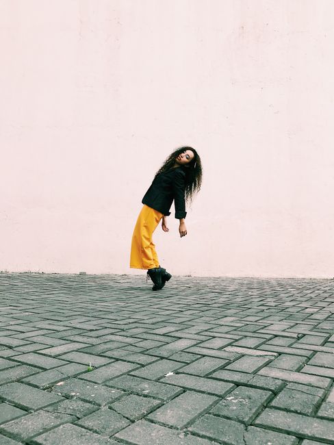 Stylish woman posing in vibrant attire against a minimalistic outdoor backdrop in Pasay.