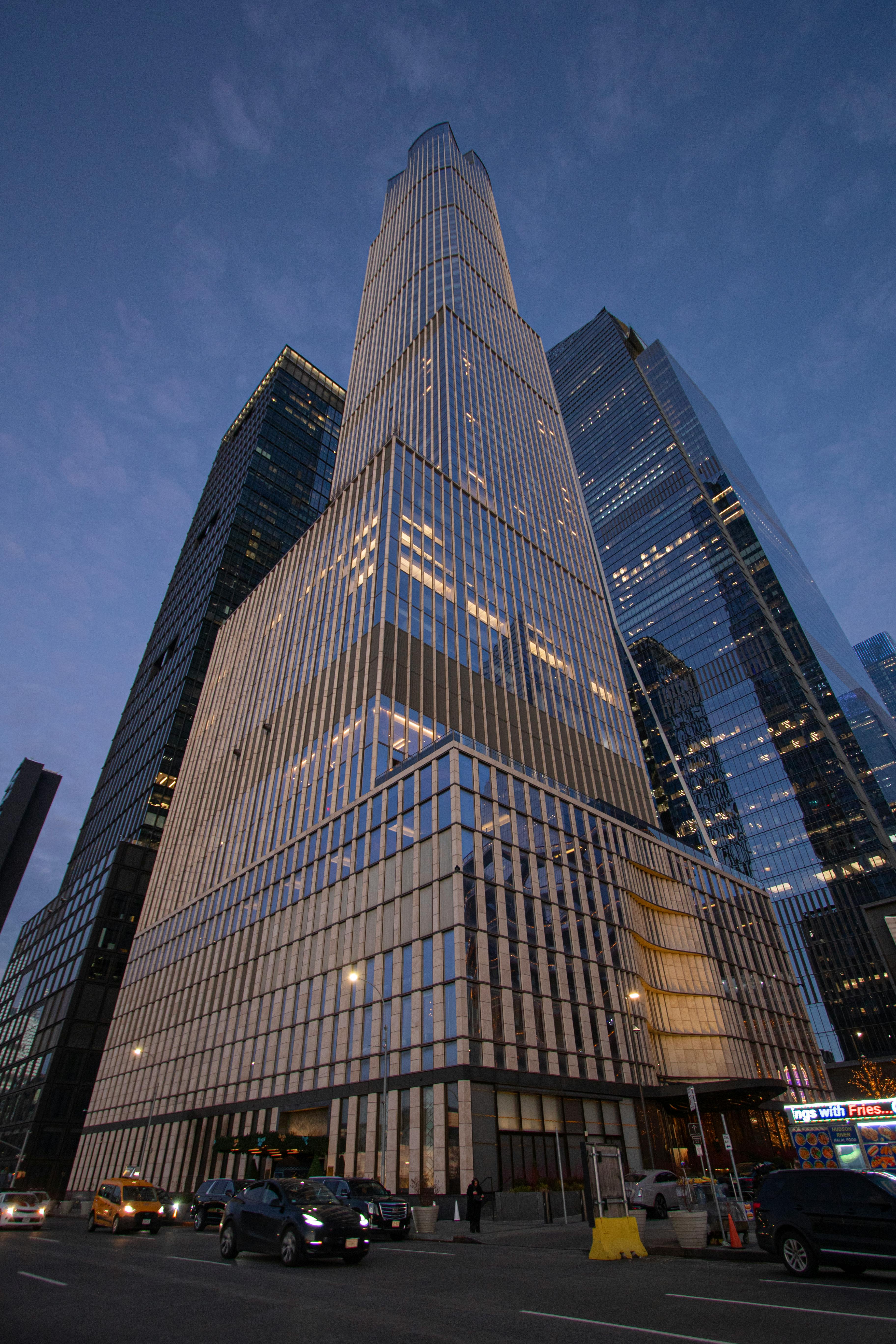 Zadarmo Tyčiaci sa mrakodrap v New Yorku za súmraku, obklopený ďalšími modernými budovami. Fotka z fotobanky