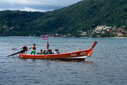 Colorful longtail boat with tourists on a scenic ride in Thailand's beautiful waters.