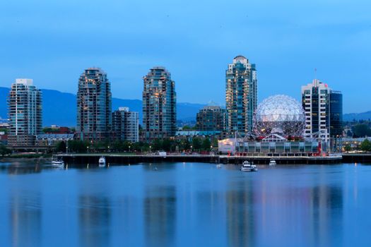 Stunning view of Vancouver's skyline including iconic Science World at twilight with serene water reflections.