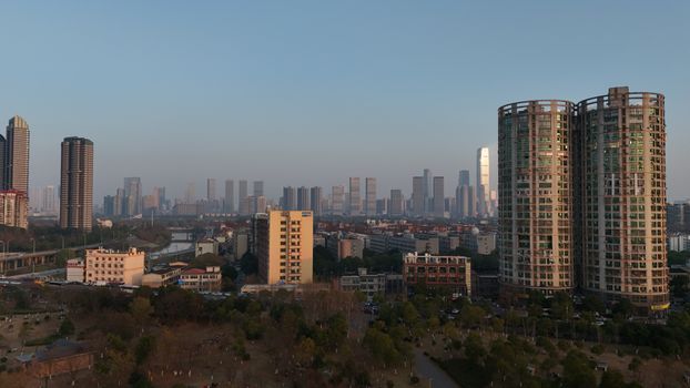 Aerial view of Changsha's modern skyline with high-rise buildings and urban landscape at sunset.