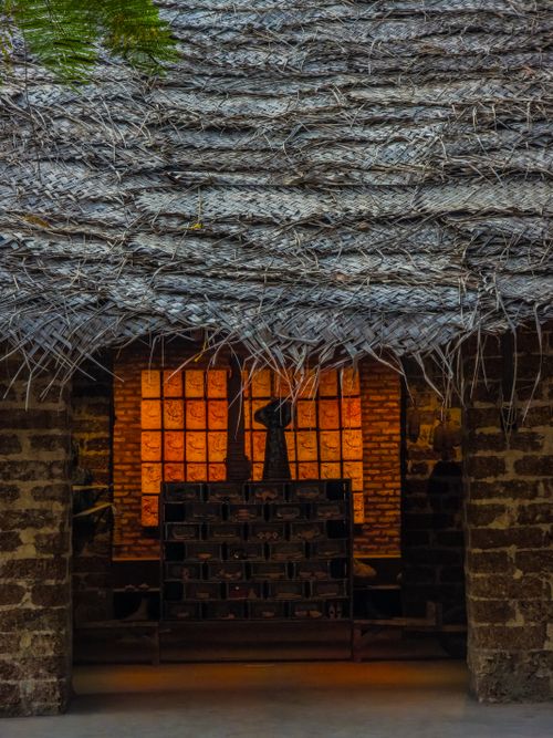 Free Entrance with thatched roof and illuminated interior, showcasing rustic architecture. Stock Photo