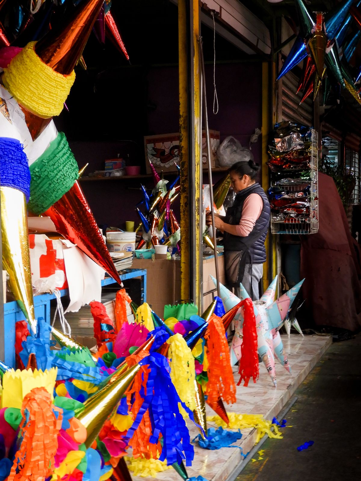 Puesto de mercado mexicano con piñatas coloridas