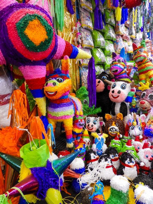 Free Colorful handmade Mexican piñatas displayed at a bustling market in Mexico City. Stock Photo