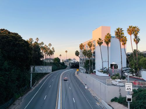 Free A serene highway view near Santa Monica with palm trees and a clear sky. Stock Photo