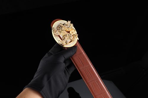 Free Elegant gold belt buckle with intricate design, held by a gloved hand on a brown leather strap. Stock Photo