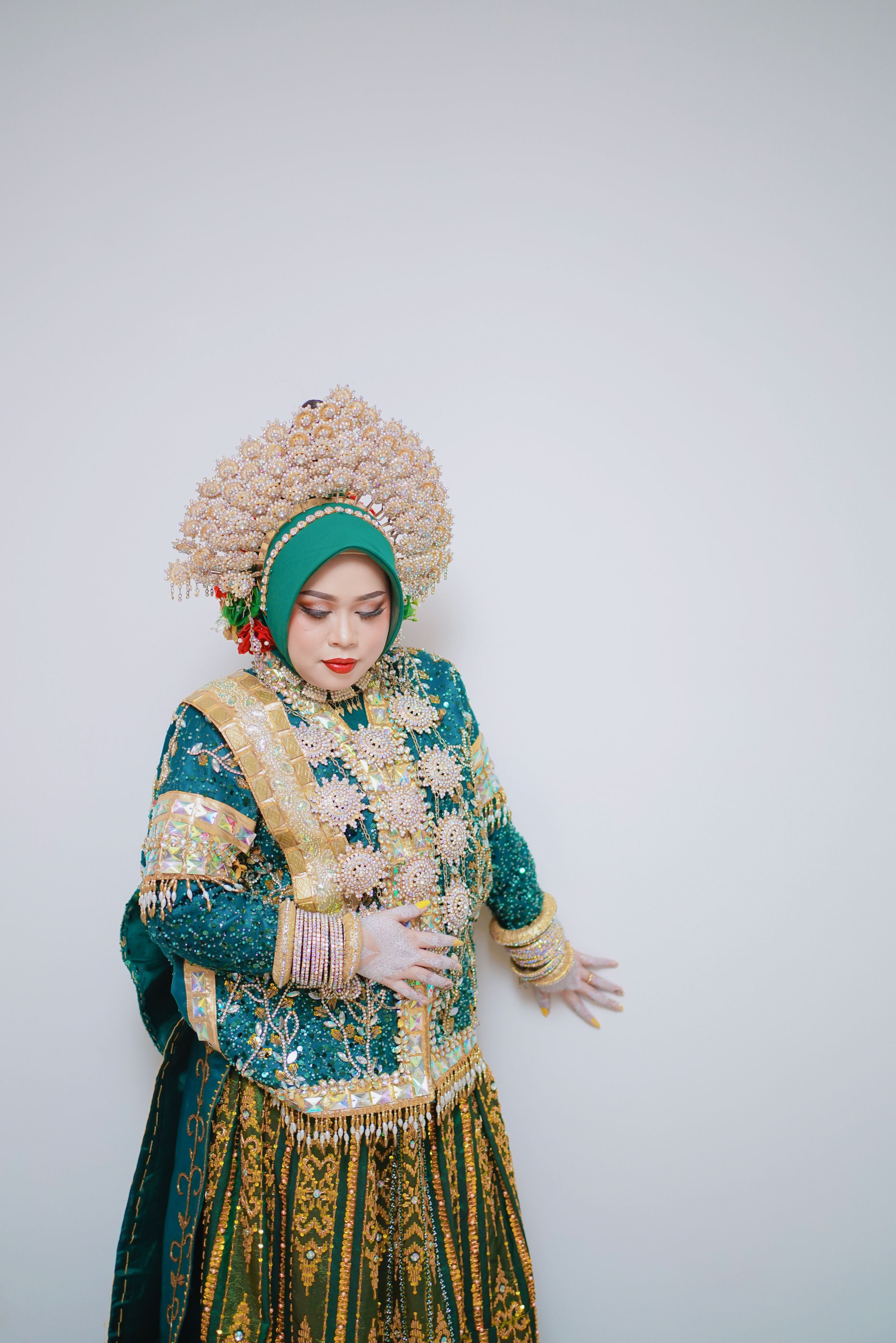 A bride in vibrant traditional attire, showcasing Indonesian cultural heritage in Makassar.