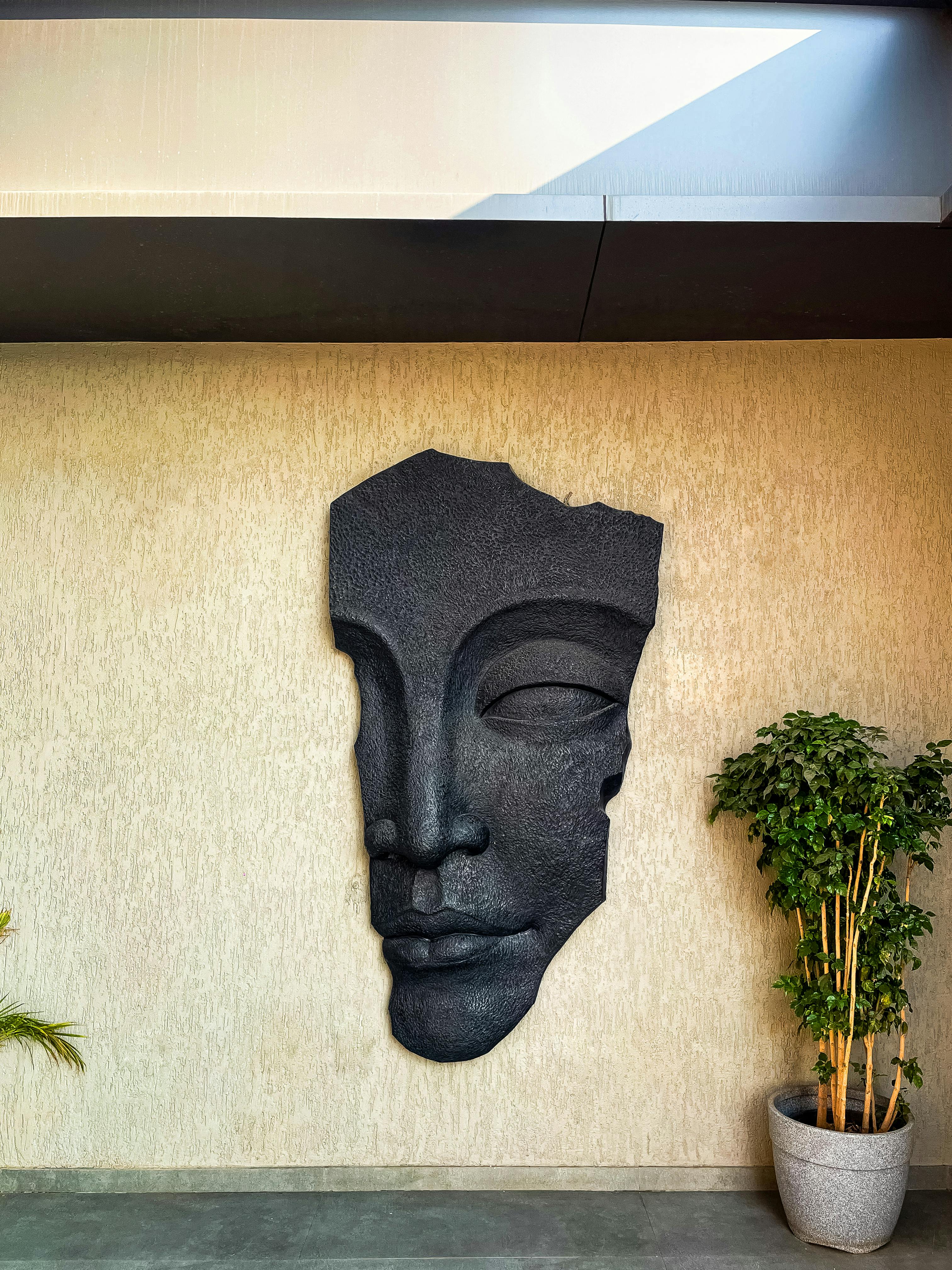 A large stone sculpture of a face adorns an indoor wall, adding artistic flair.
