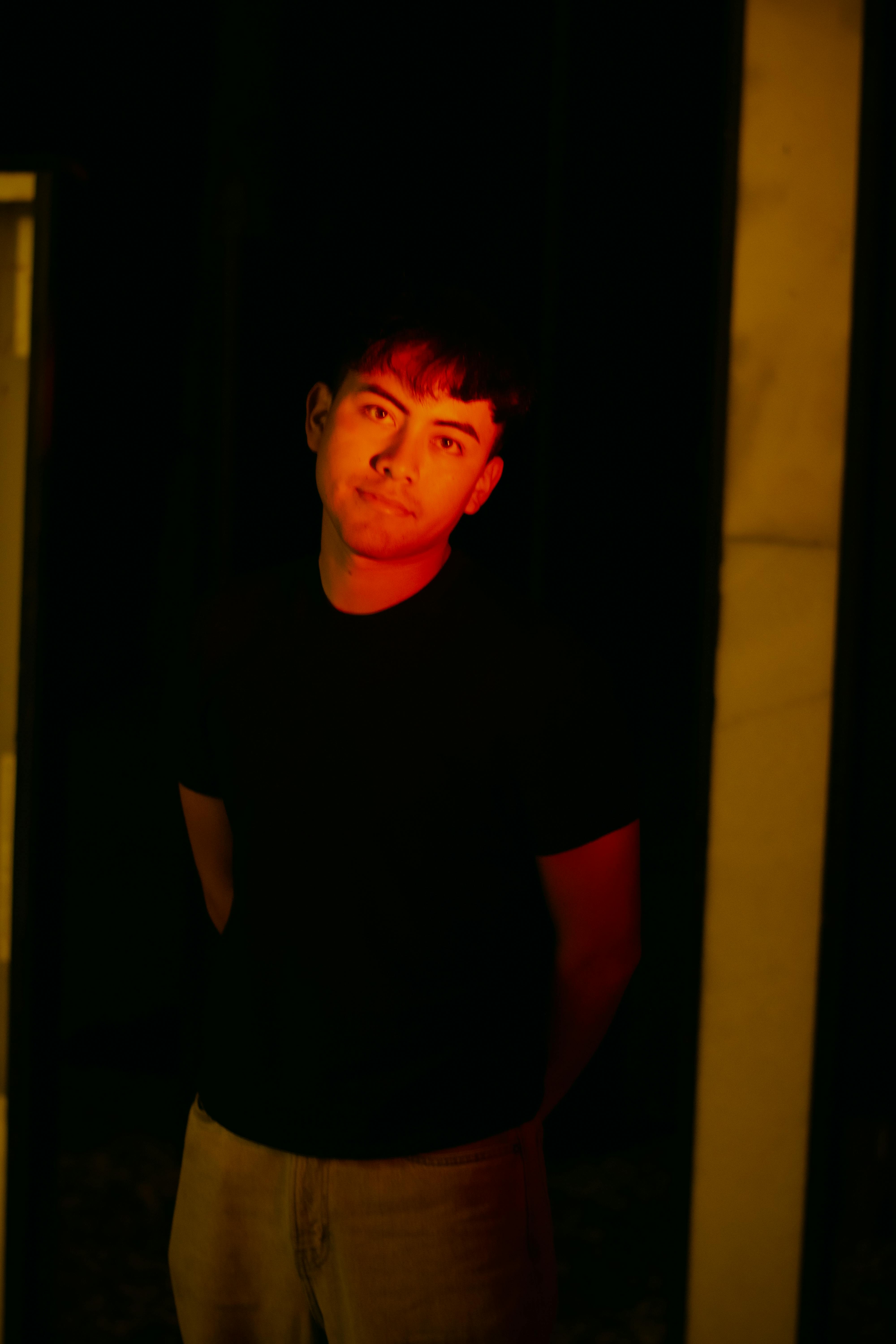 Gratis Kunstnerisk portrett av en ung mann badet i mystisk rødt lys. Arkivbilde