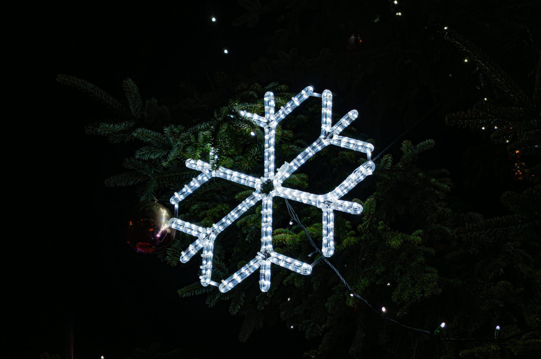 Close-up of Christmas snowflakes projected on a bedroom ceiling at night