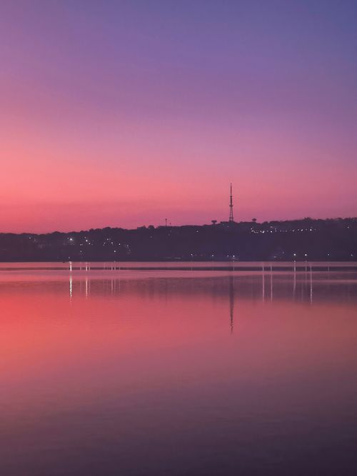 Free Beautiful sunrise over Bhopal Lake, India, showcasing vibrant colors and serene reflections. Stock Photo