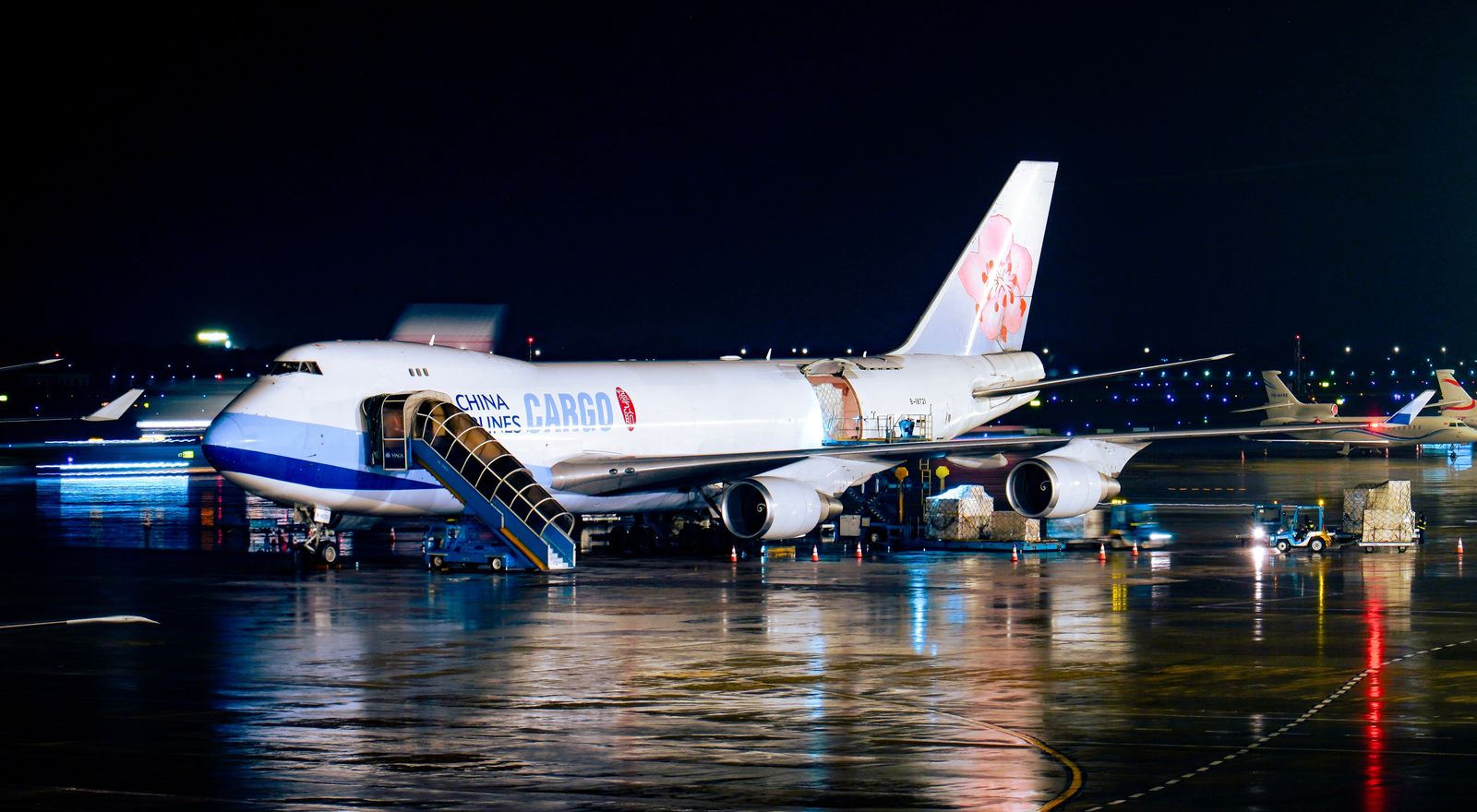 Cargo airplane being loaded at night at the airport