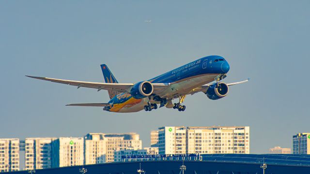 Vietnam Airlines plane taking off from Ho Chi Minh City airport with urban skyline background. — lounges at Ho Chi Minh City Airport