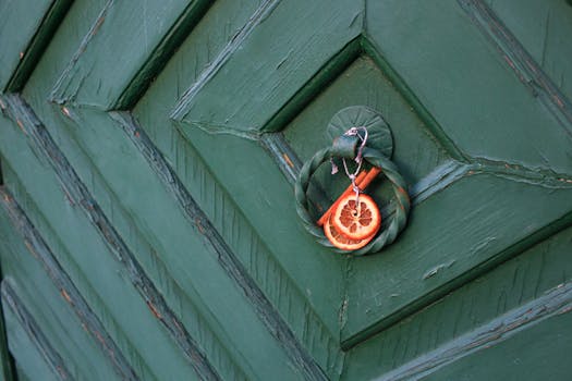 Green door with a dried citrus and cinnamon ornament, adding rustic charm.