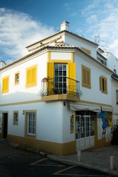 A picturesque corner building with yellow shutters in the old town of Lagos, Portugal.
