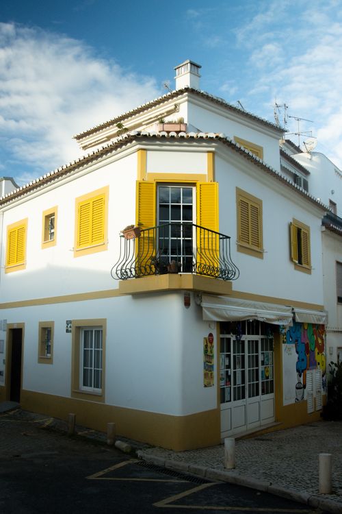 Free A picturesque corner building with yellow shutters in the old town of Lagos, Portugal. Stock Photo